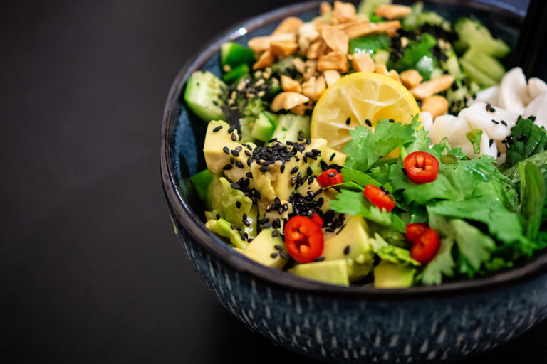 Eine Bowl mit Avocado, Zitrone, Salat, Chili und Nüssen.