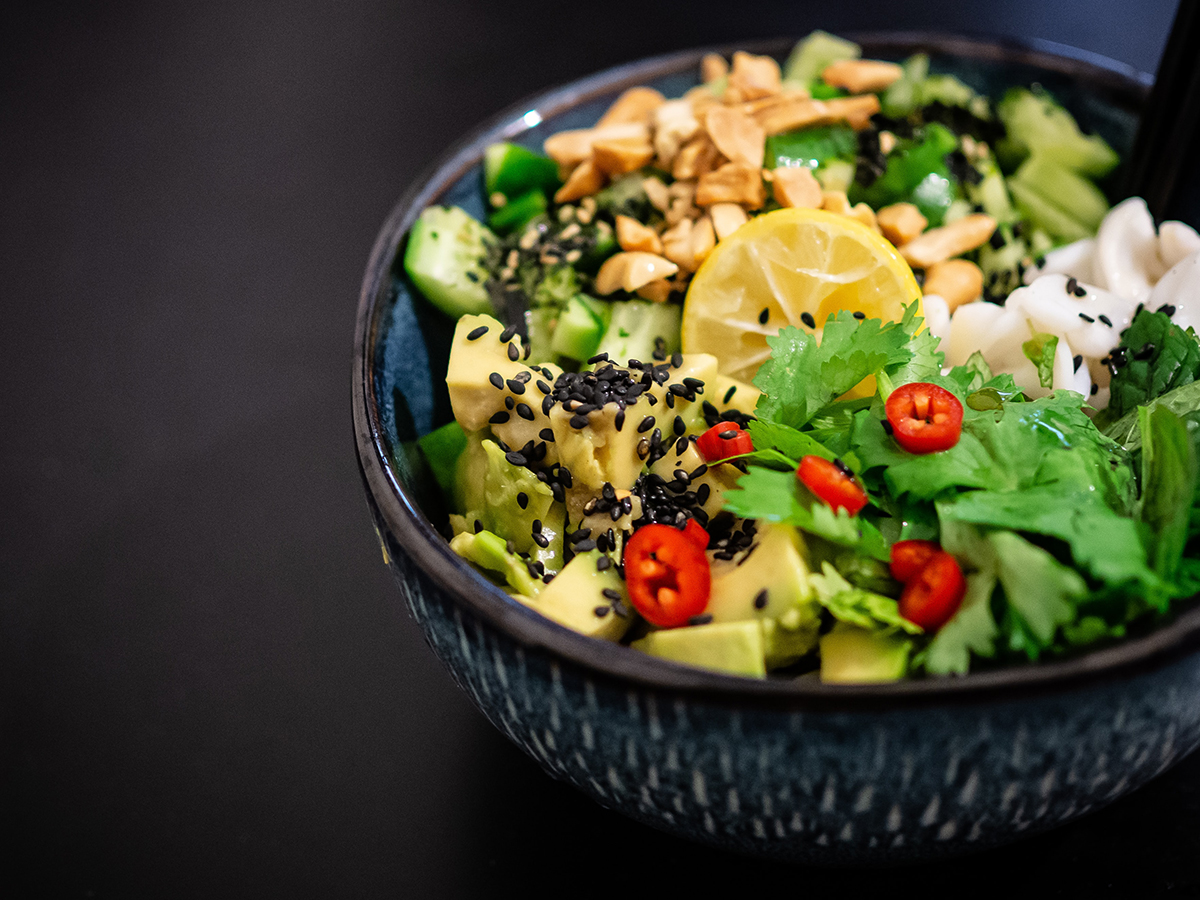 Eine Bowl mit Avocado, Zitrone, Salat, Chili und Nüssen.